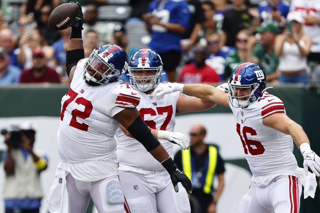 New York Giants guard Max Garcia (72) spikes the ball after tight end Austin Allen (46) caught a touchdown pass as Josh Rivas (67) looks on during the fourth quarter of an NFL pre-season football game, Sunday, Aug. 27, 2022, in East Rutherford, N.J.. (AP Photo/Rich Schultz)